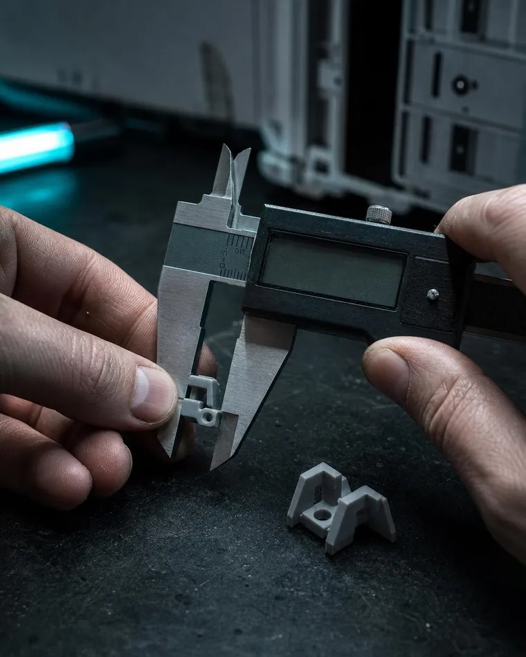 Calipers measuring a plastic clip next to its printed replacement